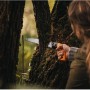 Frau sägt mit Fiskars Ast-, Hand- und Baumsäge SW 84 einen Baumstamm im Garten.