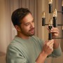 Mann schraubt Philips Hue Filament LED-Kerze E14 in eine Lampe.