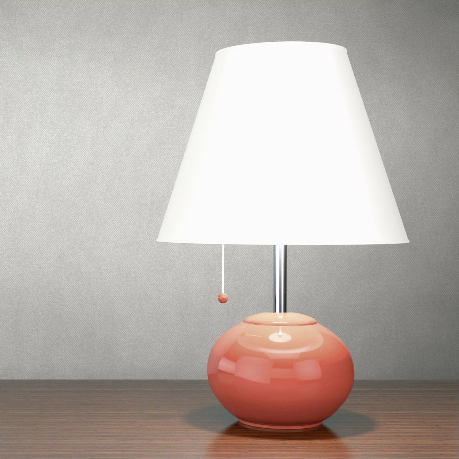 Moderne Tischlampe mit weißem, konischem Schirm und glänzendem, runden, korallfarbenen Fuß auf Holztisch.