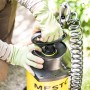 Gelbes Mesto Profi 5 Drucksprühgerät mit Spiralschlauch in Nutzung.