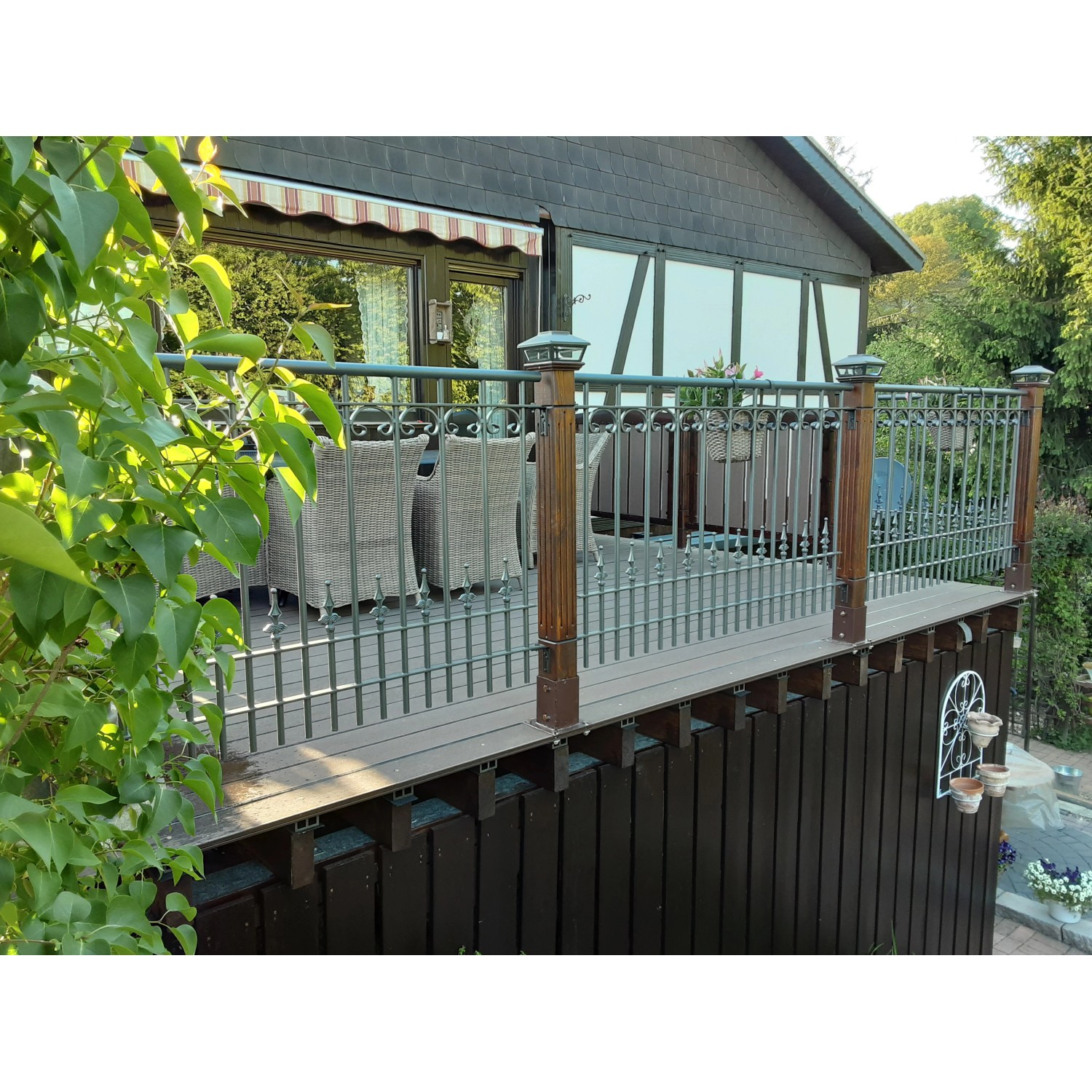 Unbeschichtetes Eleo Geländer Lucca (96x90cm) aus Schmiedeeisen mit Zierelementen auf einer Terrasse.