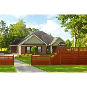 Teakfarbener Sichtschutzzaun Nicea (180x180cm) vor einem Haus mit Garten.