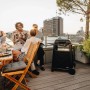 Enders Elektrogrill eUrban 2 Mobil mit Trolley auf Dachterrasse. Schwarzer Grill, Freunde genießen BBQ.