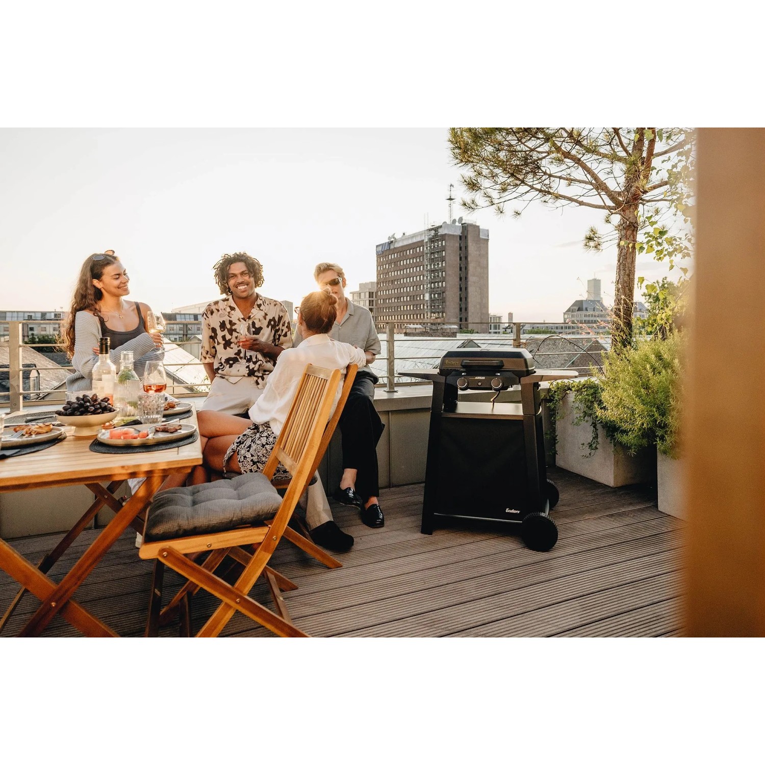 Enders Elektrogrill eUrban 2 Mobil mit Trolley auf Dachterrasse. Schwarzer Grill, Freunde genießen BBQ.