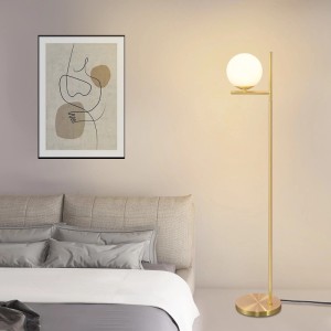 Goldene Stehlampe mit weißem Glaskugel-Schirm im Vintage-Metalldesign neben Bett. E27-Fassung, Fußschalter.