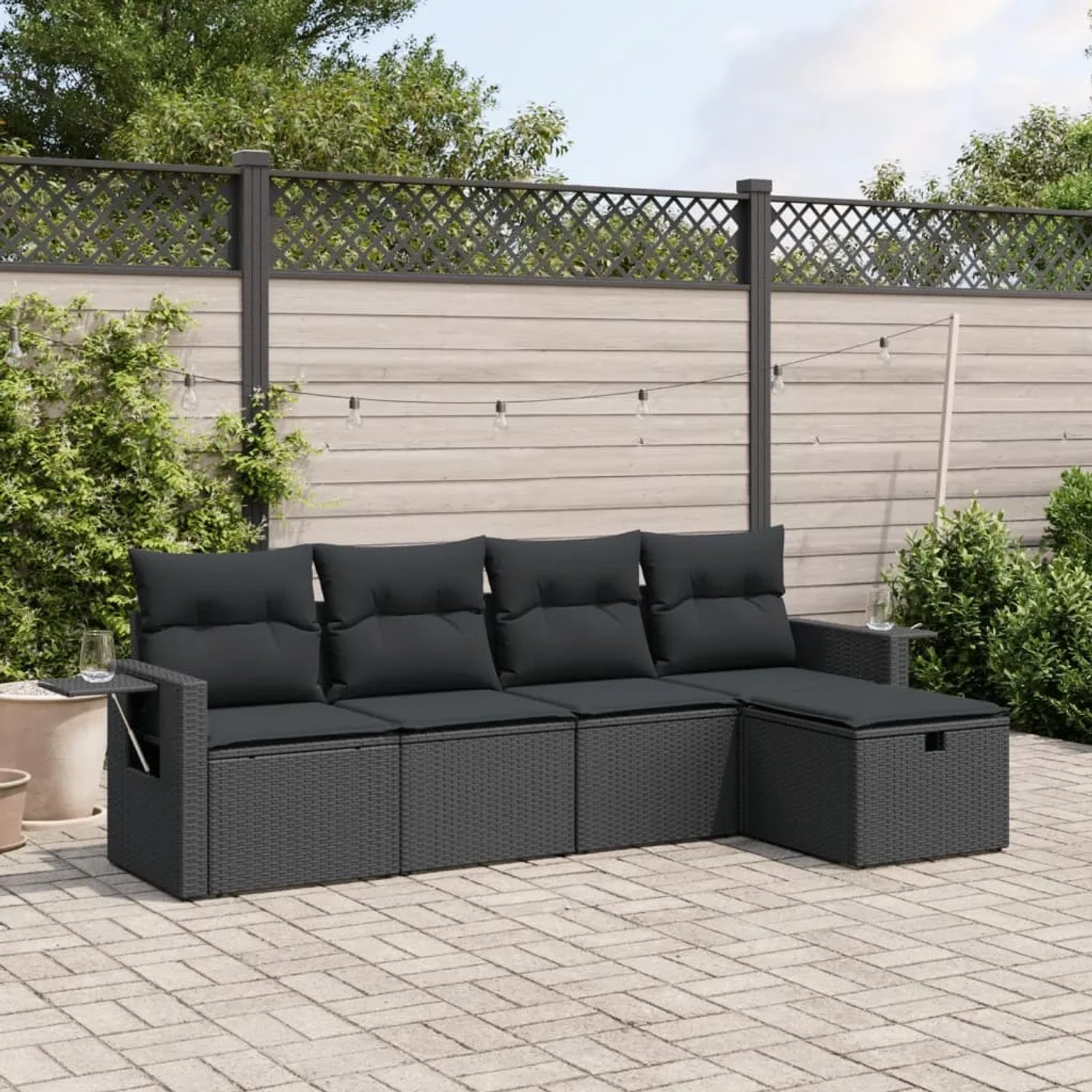 Schwarze 5-tlg. vidaXL Garten-Sofagarnitur aus Poly Rattan mit Kissen im Garten.