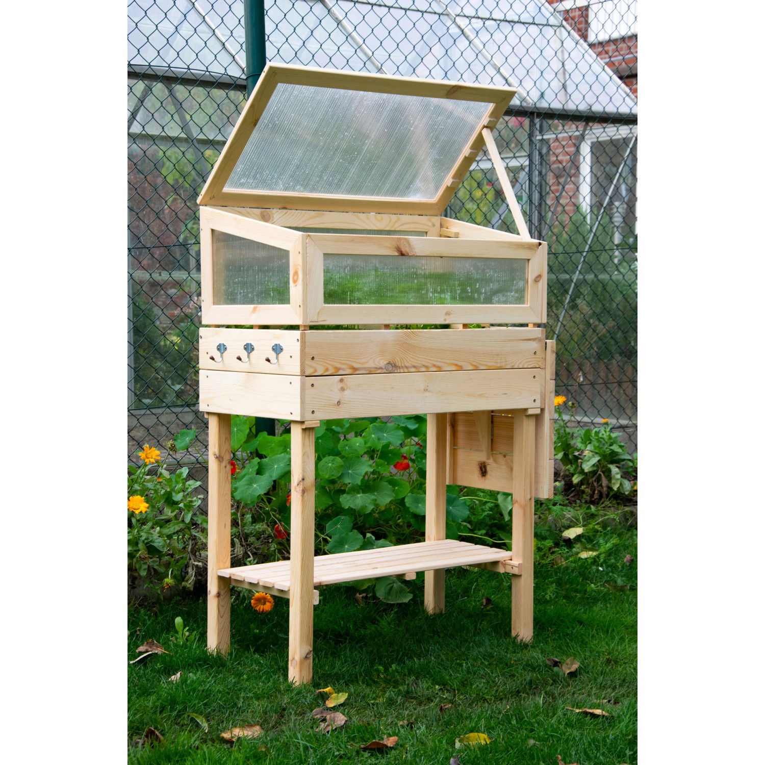 Frühbeet Tisch mit Ablage (Größe M) aus Holz, mit Polycarbonat-Aufsatz im Garten.