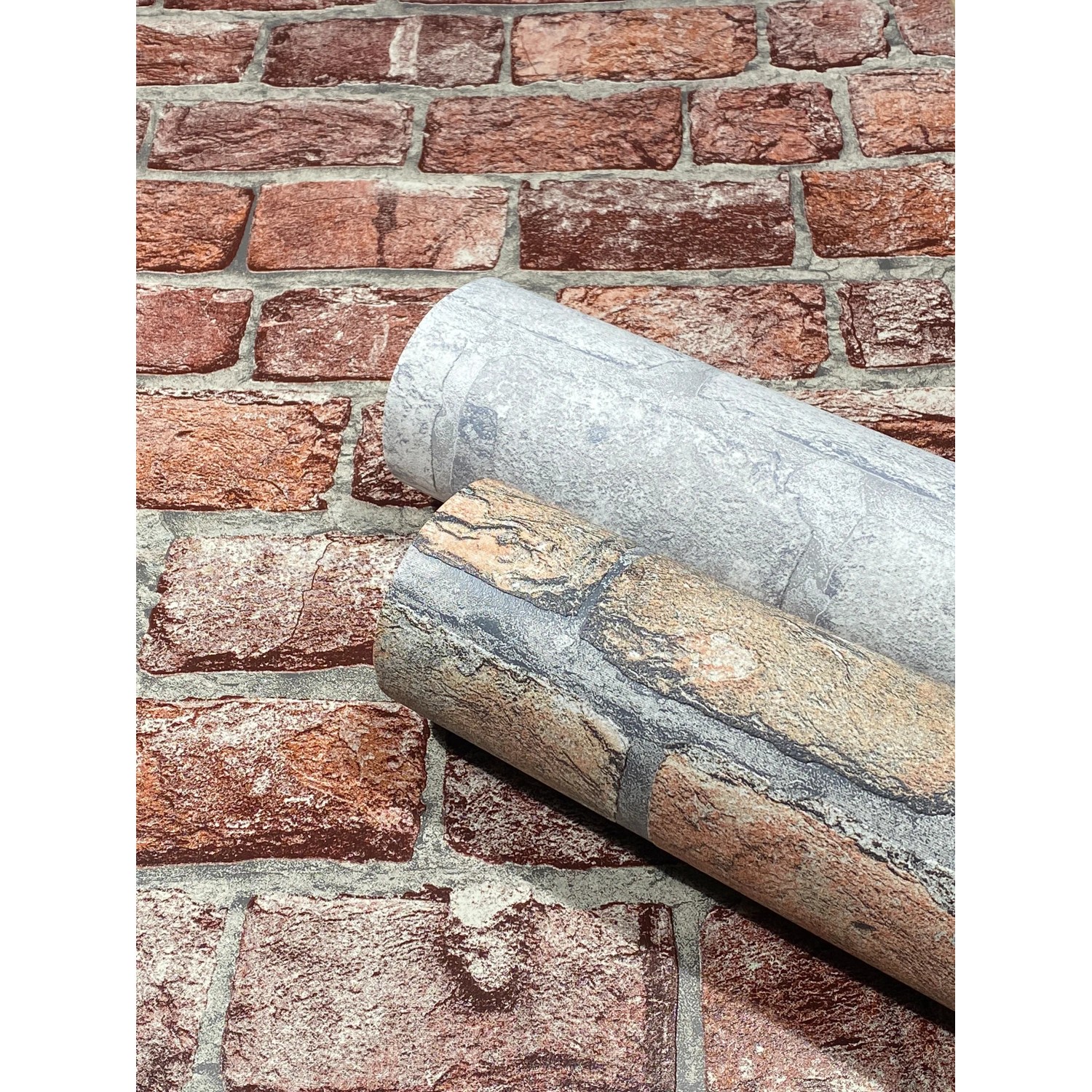 Marburg Vliestapete GZSZ 3D Steinoptik Grau, zwei Rollen vor einer Backsteinwand.
