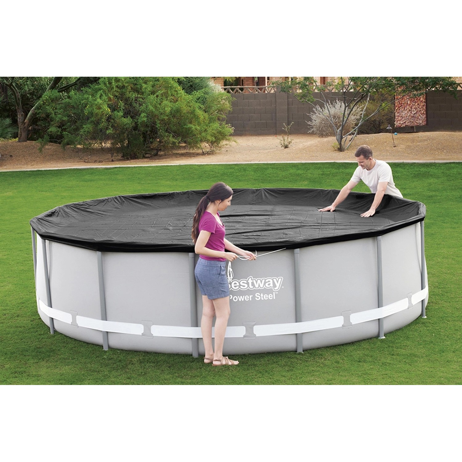 Graue Flowclear Pool Abdeckplane (427x427 cm) auf rundem Aufstellpool mit zwei Personen.