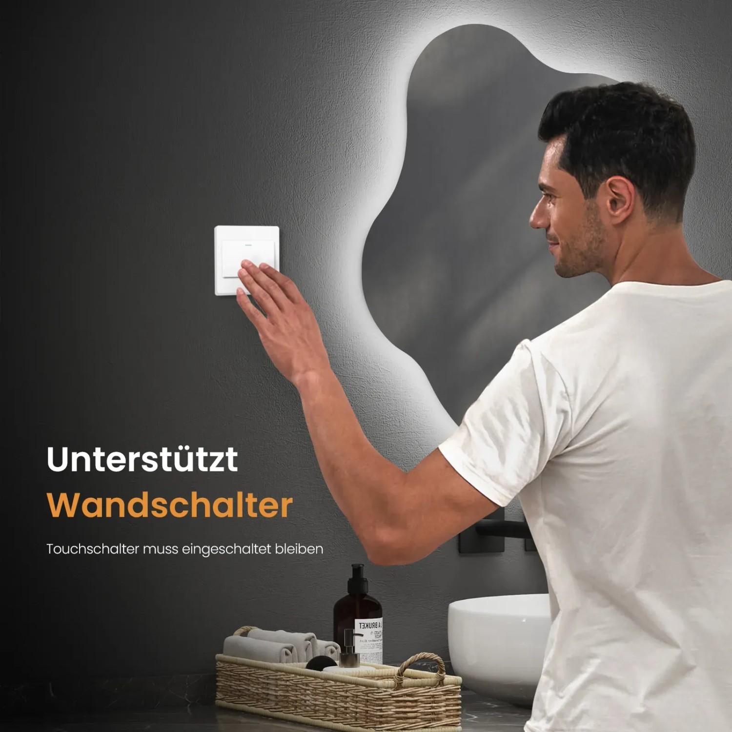 Mann schaltet LED Badspiegel ein. Asymmetrischer Spiegel mit Beleuchtung im Bad.