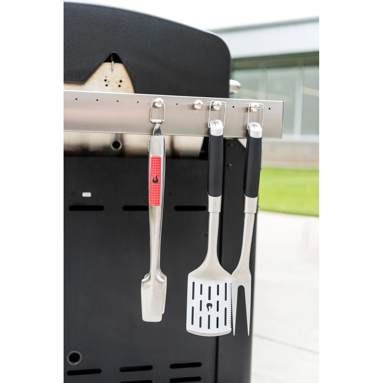 Char-Broil Gear Trax Haken mit Grillzange, Wender und Gabel am Grill.