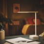 Weiße Philips LED Schreibtischleuchte Tilpa mit Akku auf einem Schreibtisch.
