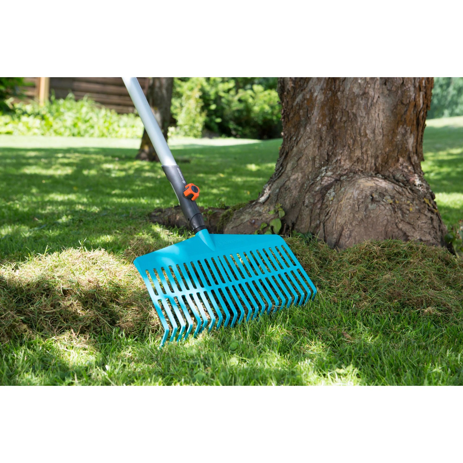 Gardena Combisystem Rechenbesen im Einsatz zum Zusammenfegen von Grasschnitt im Garten.