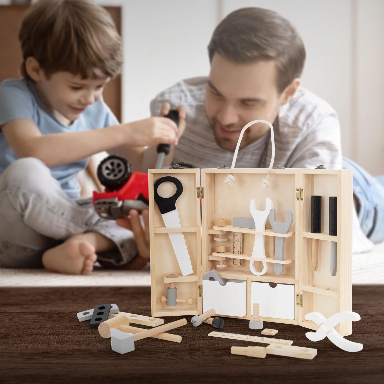 Joyz Werkzeugkasten für Kinder mit Holzwerkzeug, geöffnet mit spielenden Vater und Sohn im Hintergrund.