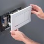 Weiße Geberit WC-Drückerplatte wird in Sigma UP-Spülkasten montiert. Installation des DuoFresh Systems für WC.