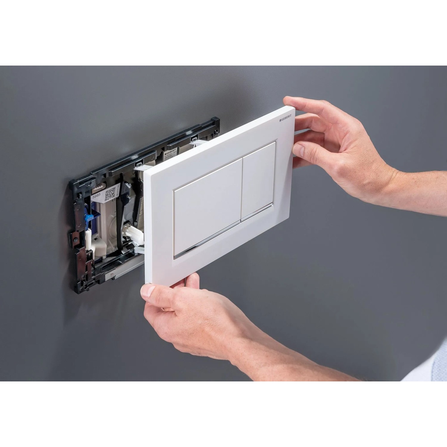 Weiße Geberit WC-Drückerplatte wird in Sigma UP-Spülkasten montiert. Installation des DuoFresh Systems für WC.