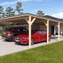 Doppelcarport Ralf mit Geräteraum, Holzkonstruktion mit dunkelgrauem Dach und zwei geparkten Autos.