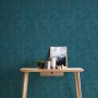 Vliestapete Trendwall 2 Uni Blau Glänzend an Wand hinter Tisch mit Deko.