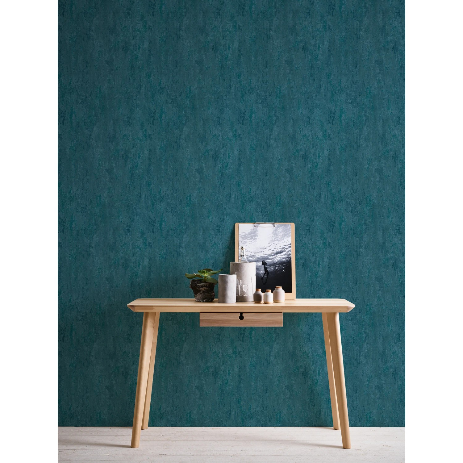 Vliestapete Trendwall 2 Uni Blau Glänzend an Wand hinter Tisch mit Deko.