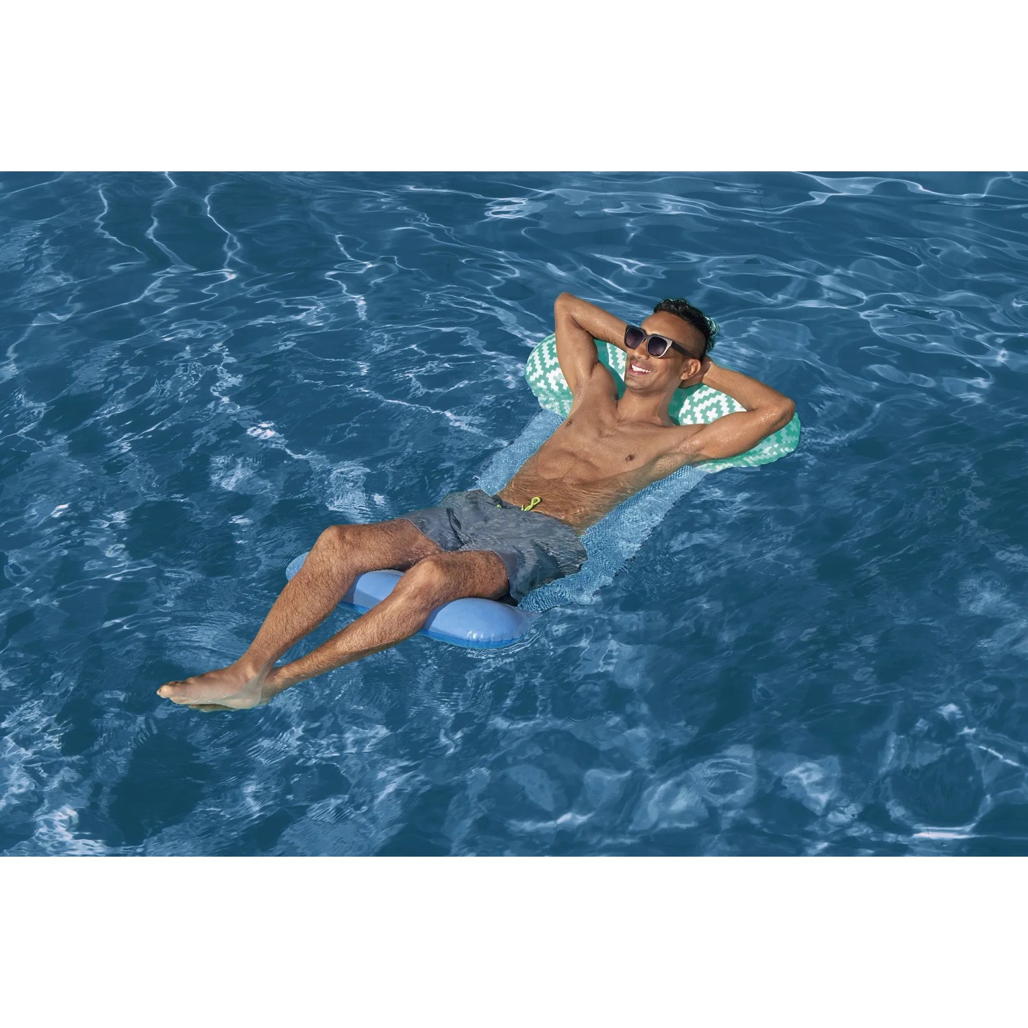 Mann entspannt auf der Bestway Pool-Hängematte Comfort Plush im Wasser.
