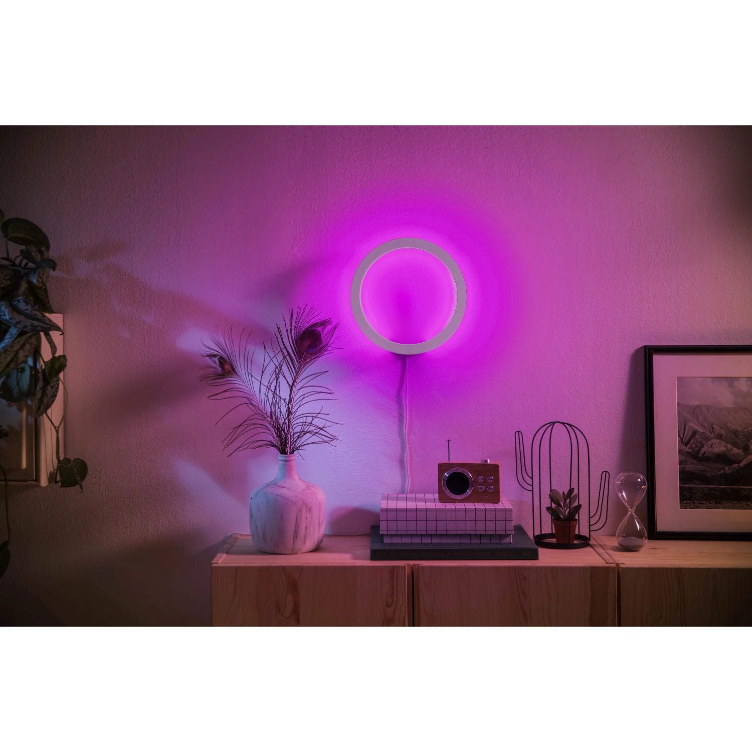 Philips Hue Sana Wandleuchte in Weiß mit farbigem Licht an der Wand.