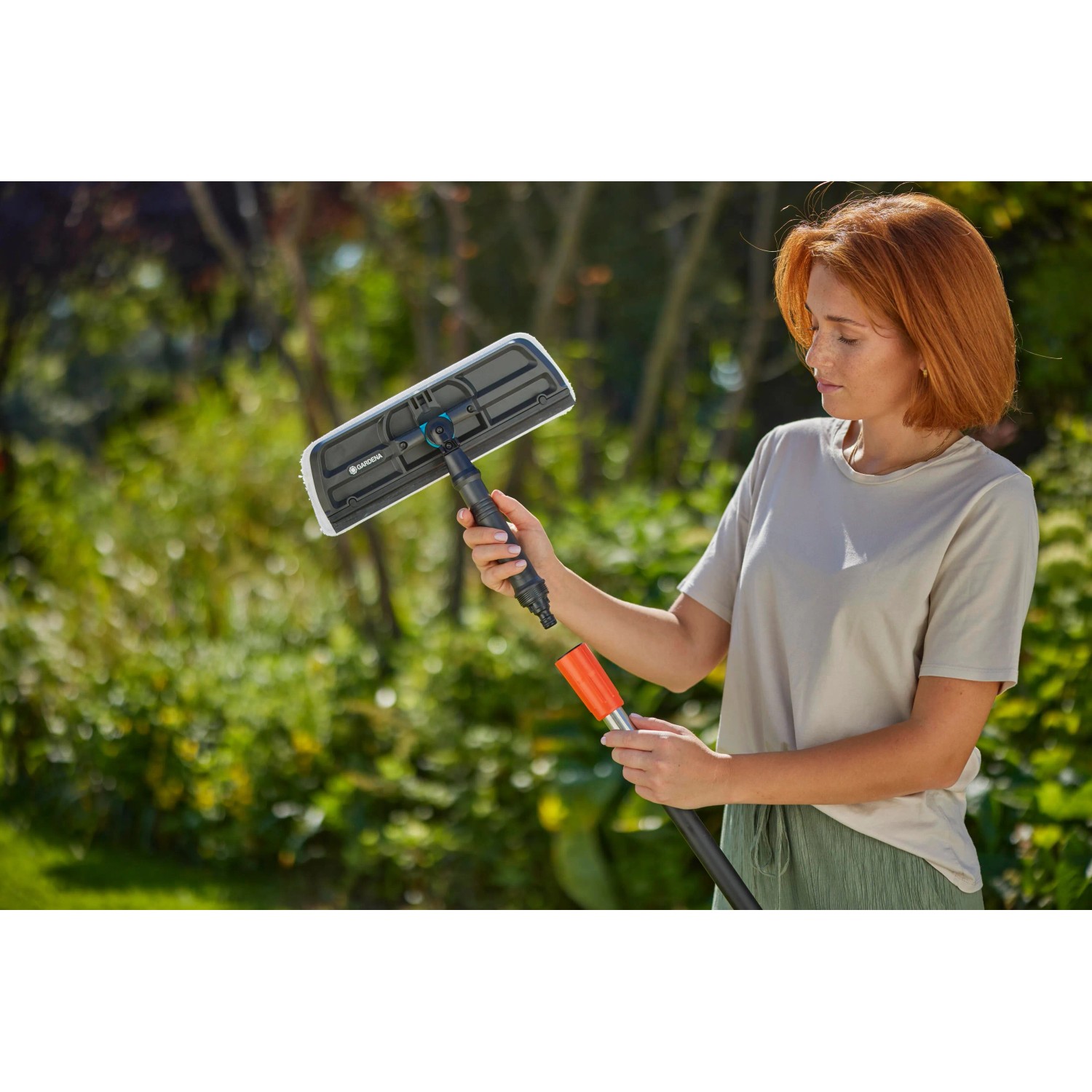 Frau nutzt Gardena Cleansystem Fensterwischer mit Mikrovlies und Abziehlippe.