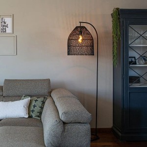 Schwarze QAZQA Stehlampe Sam mit Rattan-Schirm im Wohnzimmer.