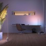 Weiße Philips Hue Gradient Signe Stehleuchte im modernen Wohnraum mit Farbverlauf.
