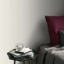 Beige Erismann Vliestapete ELLE Decoration Uni mit feiner Struktur im Schlafzimmer.