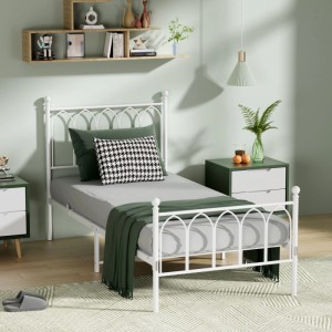 Weißes Metallbett 90x200cm mit dekorativem Kopfteil in einem Schlafzimmer. Stabiles Einzelbett für Jugend- oder Gästezimmer.