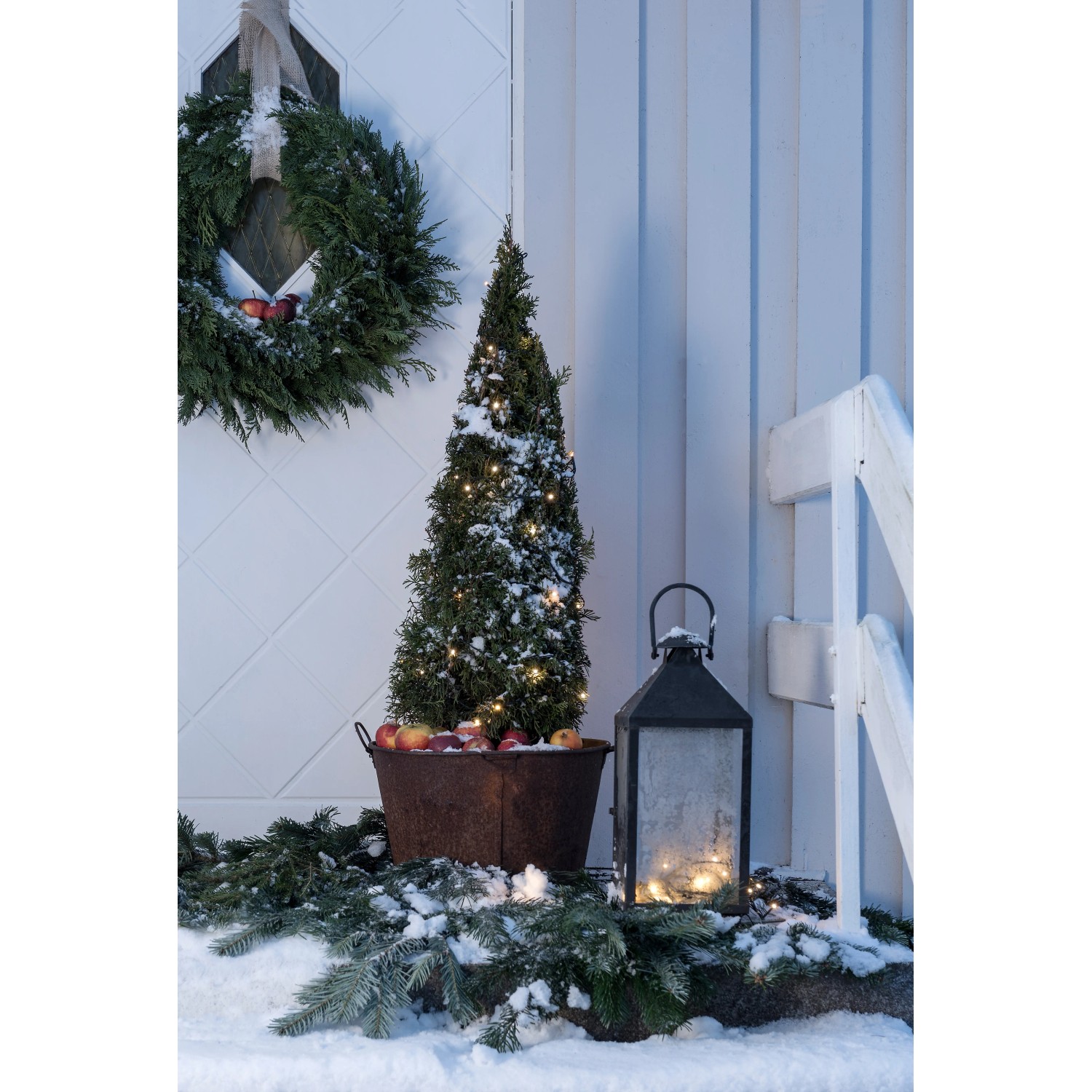 Konstsmide Micro LED Lichterkette mit warm-weißen Dioden und Außentrafo auf einer verschneiten Veranda.