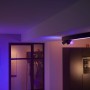Schwarze Philips Hue Centris LED-Deckenleuchte mit 3 Spots in farbig beleuchtetem Raum.
