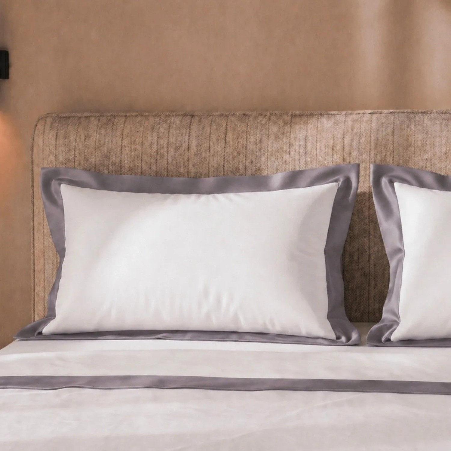Weißes Bettwäsche-Set aus Baumwolle für Einzelbett mit dunkelgrauer Satin-Bordüre auf Kissen und Decke.
