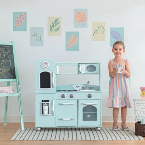 Mintgrüne Teamson Kids Spielküche mit Zubehör und spielendem Kind.