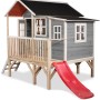 Graues EXIT Loft 350 Holzspielhaus mit Rutsche, Leiter und Anbau für Kinder zum Spielen im Garten.