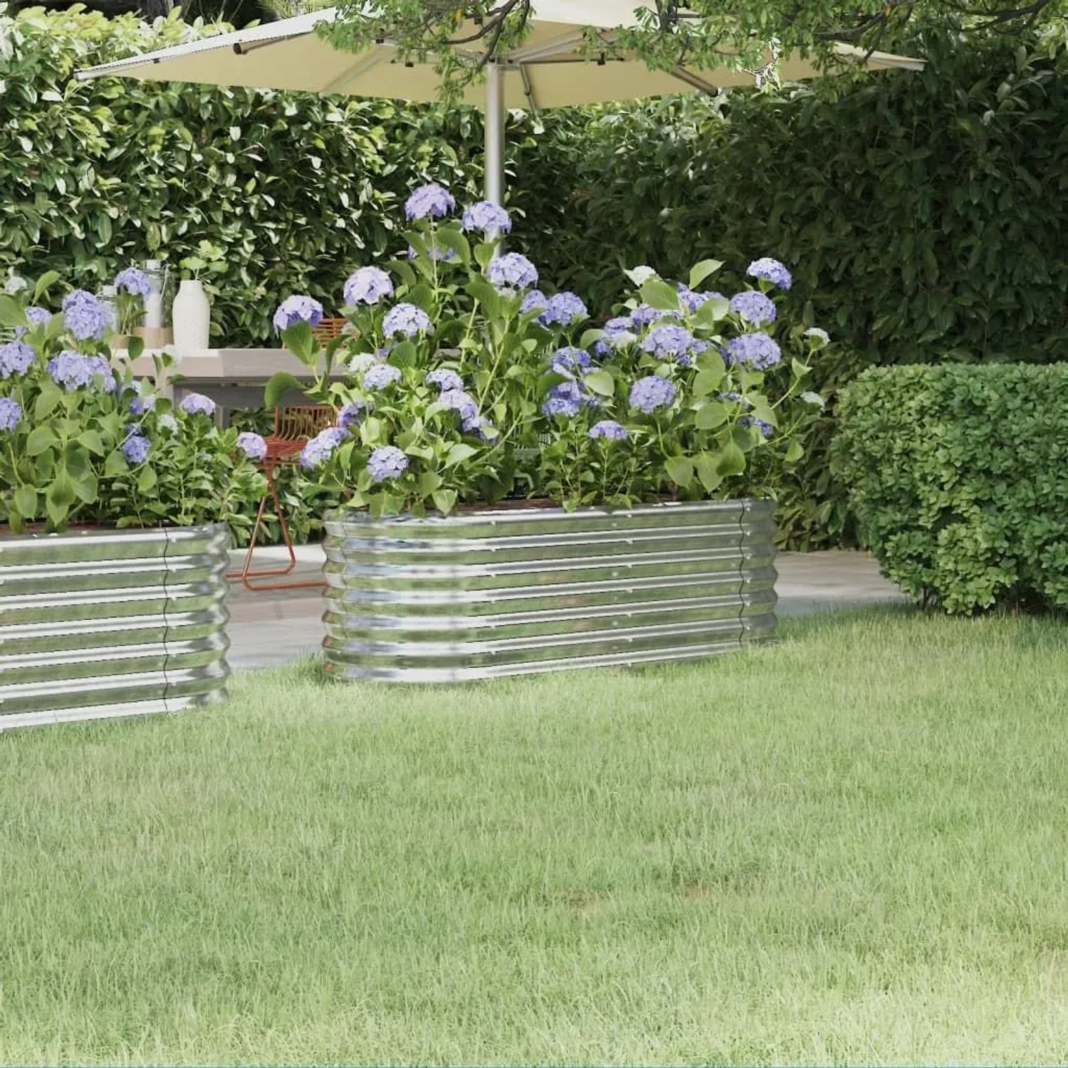 Silbernes furnicato Hochbeet aus Stahl, 114x40x36 cm, mit blühenden Hortensien im Garten.