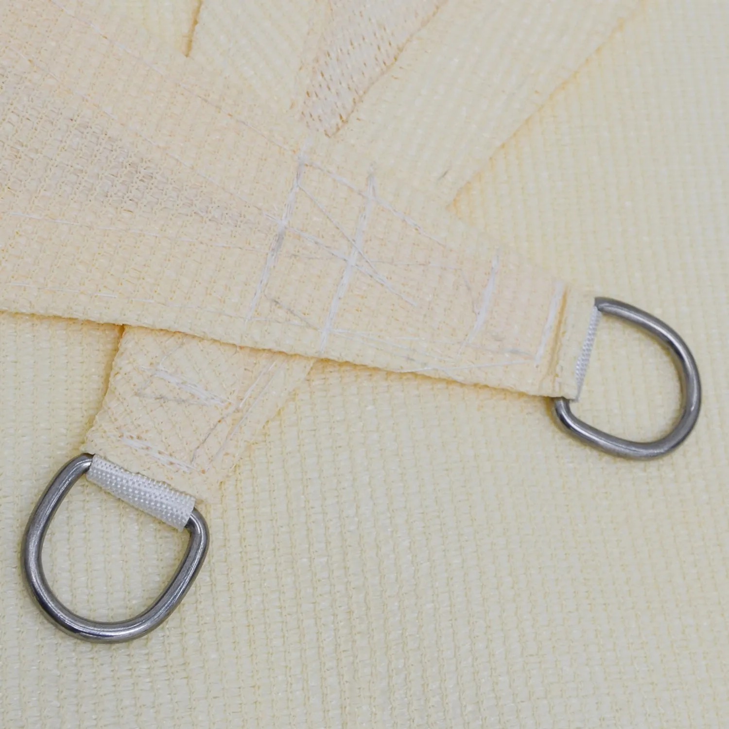 Detailansicht: Beige AMANKA Sonnensegel (6x6m) mit D-Ring aus Edelstahl. Wasserdurchlässig.