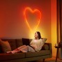 Frau mit WiZ Flex Strip als Herz an der Wand. Smarte LED Leuchte mit Farbwechsel für indirekte Beleuchtung.