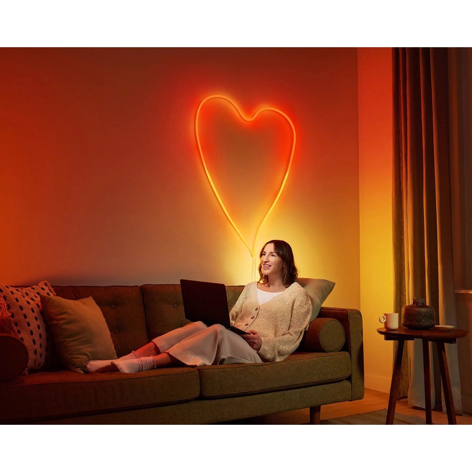 Frau mit WiZ Flex Strip als Herz an der Wand. Smarte LED Leuchte mit Farbwechsel für indirekte Beleuchtung.