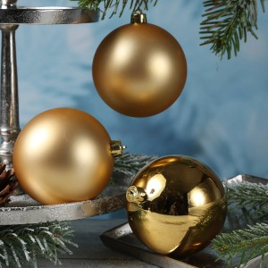 Goldene Christbaumkugeln aus Kunststoff, matt und glänzend, 10cm. Festliche Weihnachtsdeko mit Tannenzweigen.