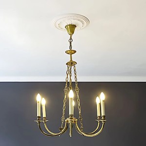 Weiße PROFHOME Deckenrosette aus Polyurethan, 40 cm Durchmesser, als Zierelement unter einer Lampe.