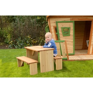 Axi Lisa Spielhaus mit Tisch und Bank, braun-grün, im Garten. Kind sitzt am Tisch.
