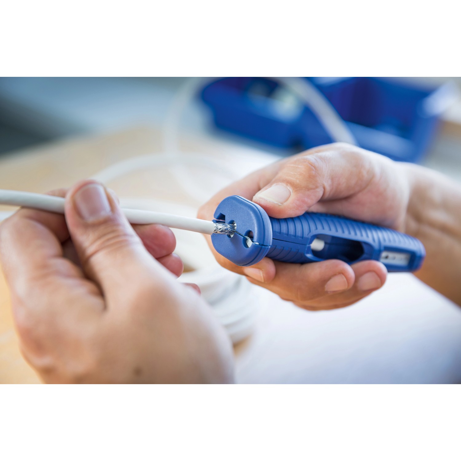 LUX 6in1 Multiabisolierer in Anwendung: Abisolieren eines Kabels mit der blauen Zange.