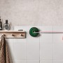 Bosch Atino Linienlaser mit Maßband im Einsatz an weißer Wand.