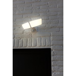 Weiße Lutec LED-Außenwandleuchte Artica mit Bewegungsmelder, 2-flammig an weißer Backsteinwand.