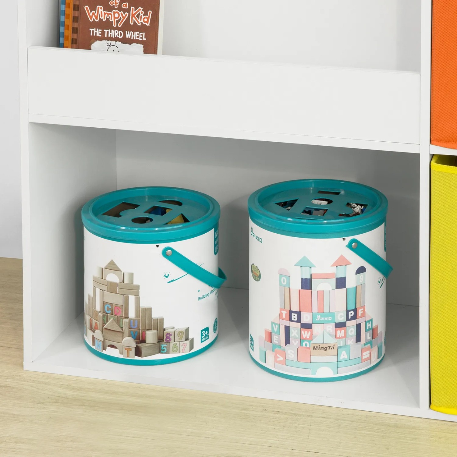 Weißes SoBuy Kinder Bücherregal mit Spielzeug und zwei Behältern mit Bauklötzen.