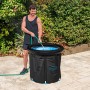 Bestway LAY-Z-SPA Eisbad Glacial Zen, ein Mann befüllt den schwarzen, runden, aufblasbaren Whirlpool mit Wasser.