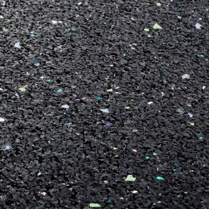 Nahaufnahme der schwarzen KARAT Antivibrationsmatte / Schallschutzmatte aus Gummigranulat mit Farbpigmenten.