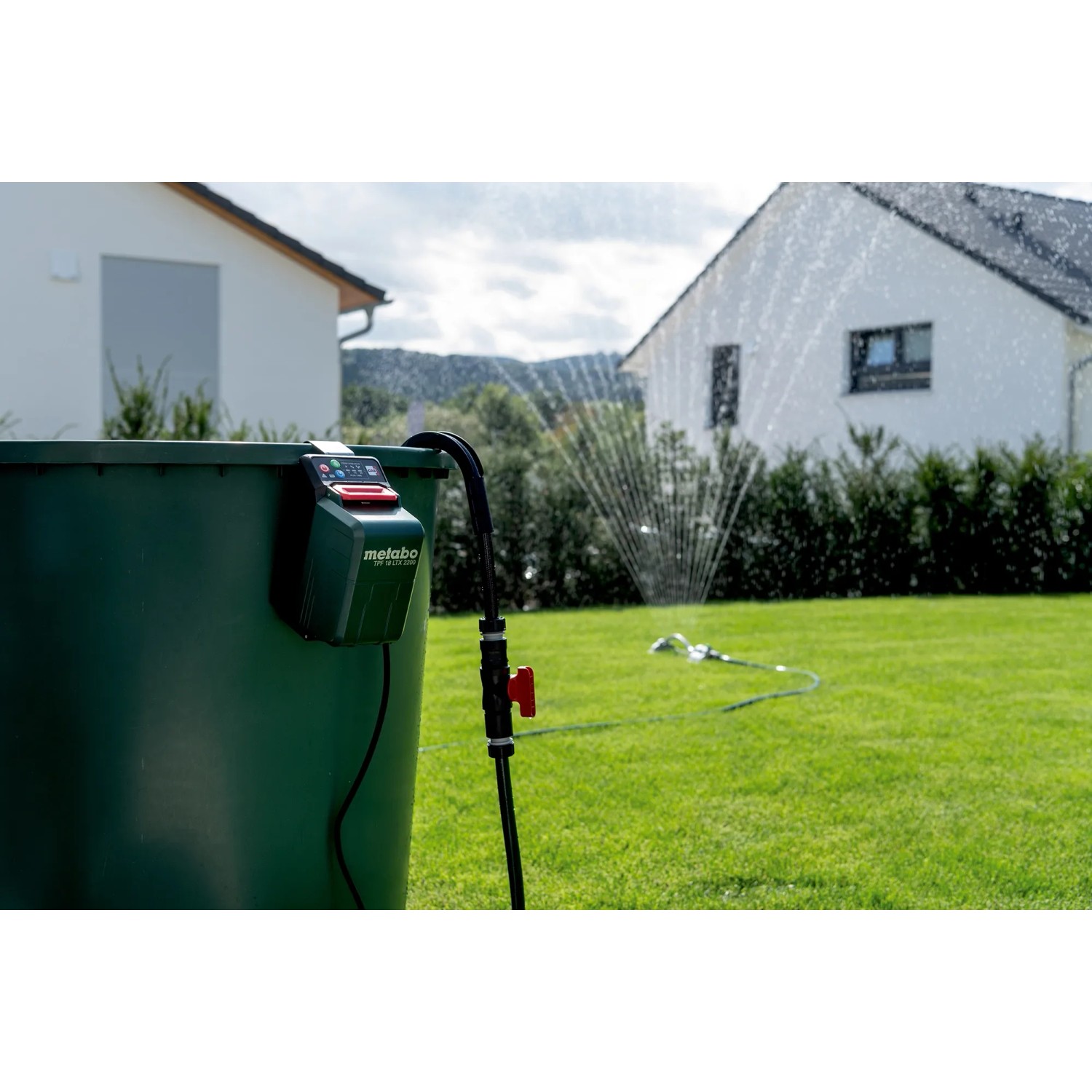 metabo Akku-Tauchpumpe TPF 18 LTX 2200 am Regenfass im Einsatz zur Gartenbewässerung.