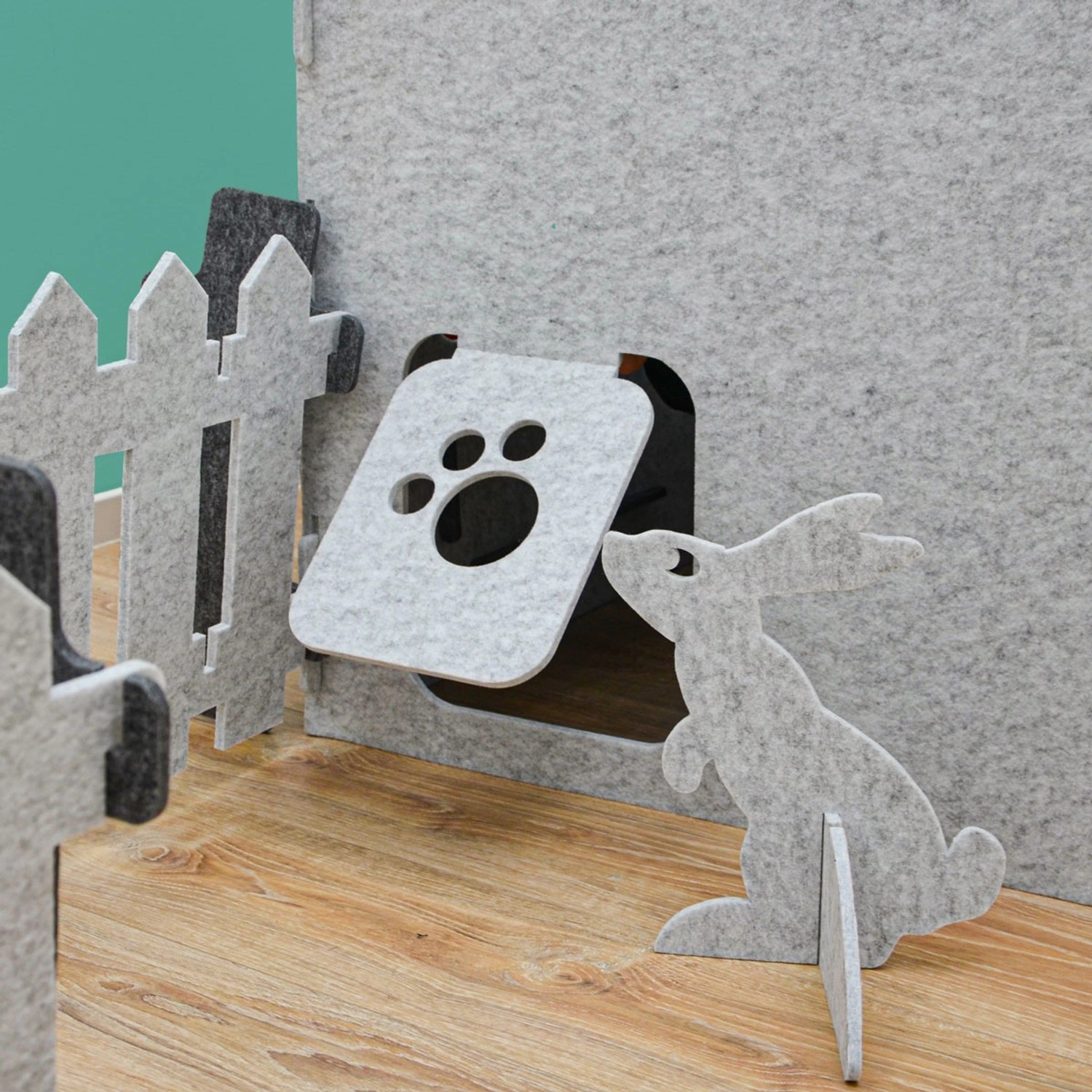 Detailaufnahme: Blaues smalla Kinder Spielhaus aus Filz mit Katzenklappe, Zaun und Hasenfigur.